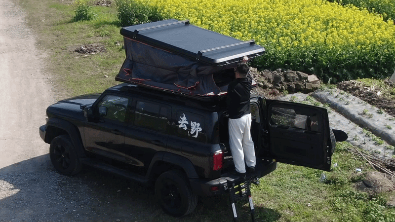 A overlander easily closing the Jiadrooe Titan T3021 aluminum hardshell tent for travel on a Toyota Tacoma rig.